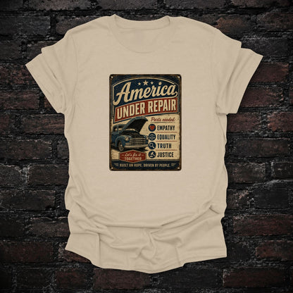 America Under Repair Political T-Shirt in Sand, flat lay mockup
